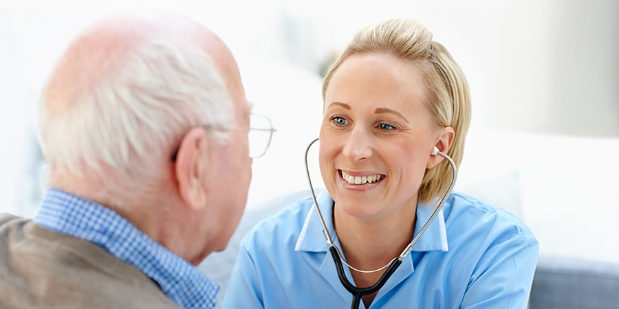 A licensed Manitoba physician treating an older patient during a covered home visit in Winnipeg